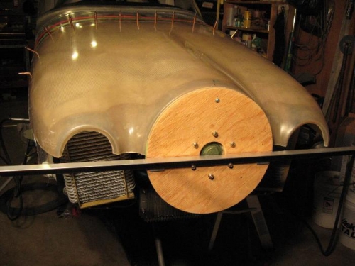 Extends past the cowl on either side.  Also note the nut/bolt holding the top cowl to the disc...