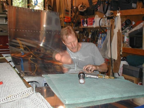 My right arm is in the wing locating the desired rivet at the rear spar with the bucking bar...