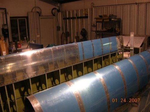 Both wings with top skins on still in jigs