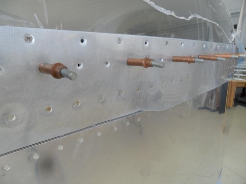 Left side skirt brace riveted along lower edge