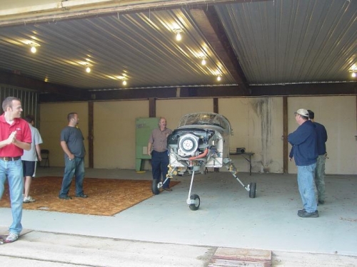 Everybody at airport helping get the plane into the hanger.