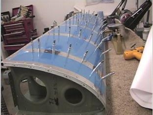 Riviting the skin to the ribs.