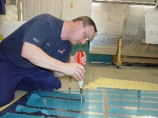 Deburing the holes in the skin of the center section.