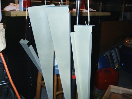 Rudder ribs hanging from wire hooks to dry