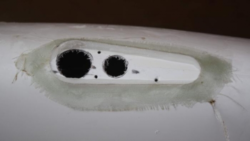 Holes drilled, fiberglass build up around bracket and RTV.