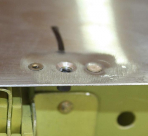 Pop rivet and countersunk screw hole.