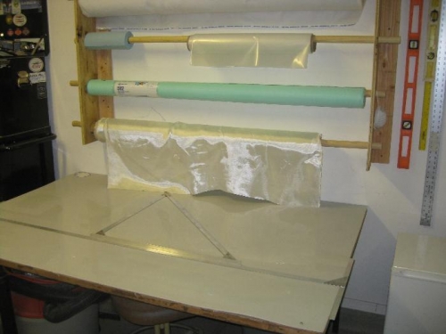 Fiberglass cutting table and spindles for peel ply and breather fabric