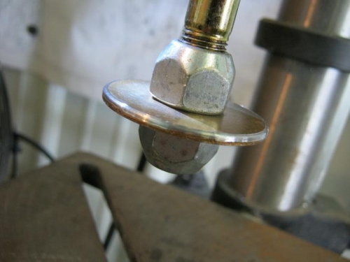 Prop bolt washer locked in drill press and using a file to bevel the edge for nice fit
