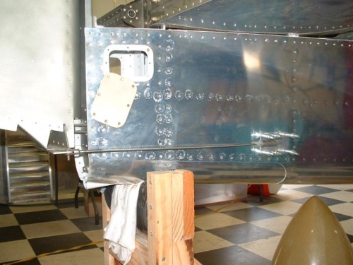 Rudder control cable exiting the fuselage and attaching to the rudder.