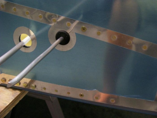 Fuel tank bracket support screwed through the skin, longeron and angle with counter sunk screws