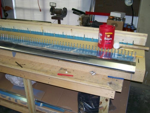 Left flap with the trailing edge Prosealed and clecoed to the table to dry.