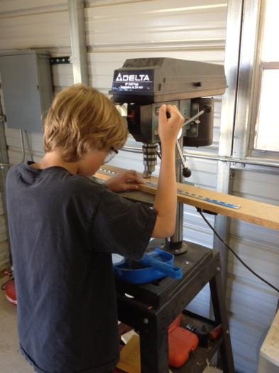 Adam drilling holes in hinges using jig