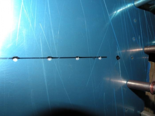 The bottom of the originally drawn center line goes through the center of the holes.