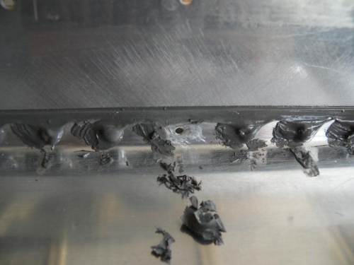 I scraped the sealant away from the bottom side, then cleaned the area with MEK.