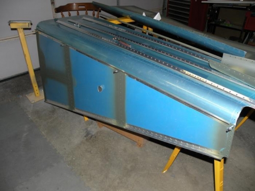 Using the aft bottom skin as a straight edge for scoring the bottom rivet lines of the aft side skins.