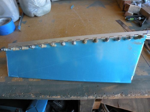 Trim tab hinge drilled to trim tab skin and spar; inboard end marked for trimming.