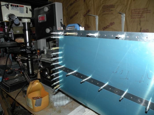 LED flashlight shining through elevator hinge holes.