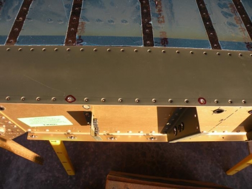Countersunk holes for rivets that will attach the aft ends of the forward floor stiffeners.