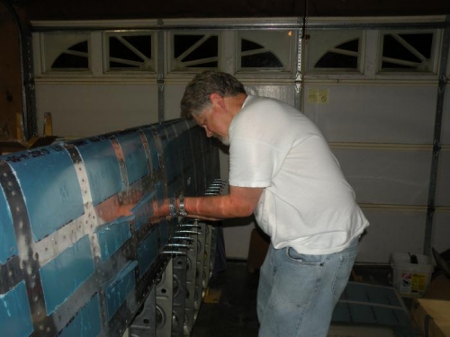 Reaching in the stall warning access hole for the inboard leading edge rivet.