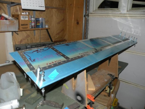 Skin overlap and bottom flange of inboard end rib are riveted.