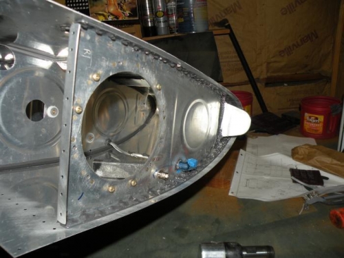 Inboard rib riveted and sealed, including vent fitting, reinforcement plate, and attach fitting.