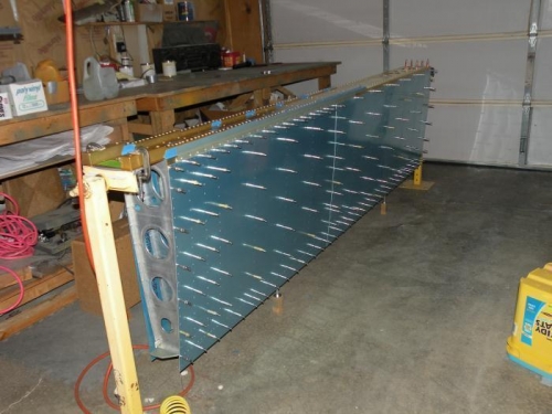 Top skins clecoed and inboard bottom skin clecoed, and bottom hanging from right wing skeleton.