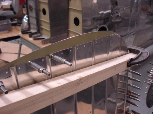 Tariler edge clamped for riveting.