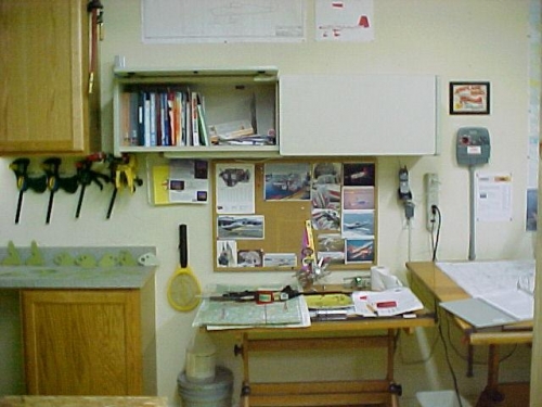 View of book cabinet.  Note phone mounted to wall next to multi-plug outlet.