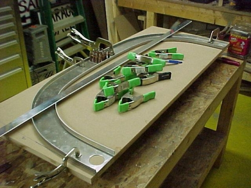The 2 aft channels of the cabin frame are clamped to the piece of MFD board and drilled.