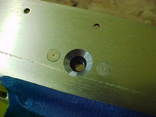 Tank skin attach platenut riveted on behind spar.  Hole is countersunk for flush connection