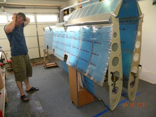 Ted inserting his ear plugs, wing skins ready to rivet