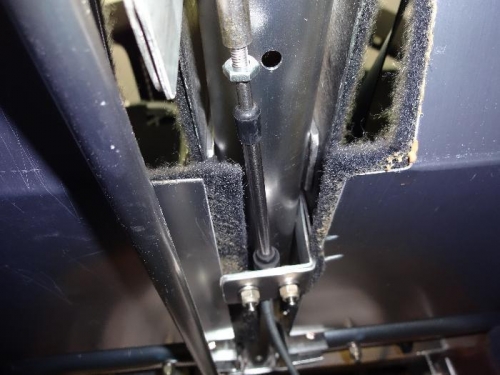 The L-Bracket holds the outer cable still is riveted to the Center Tube between the seats