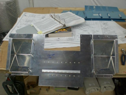 Foot wells riveted to skin