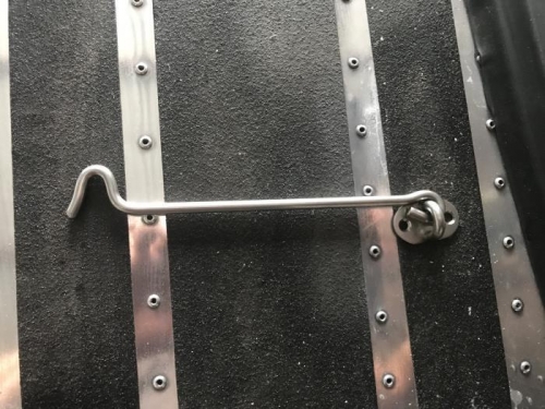 Standard steel gate hook sitting on the wing for this picture of it.