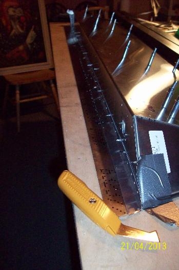 Upside-down aileron with L angle clecoed from inside ready for cutting. Note the Olfa knife.