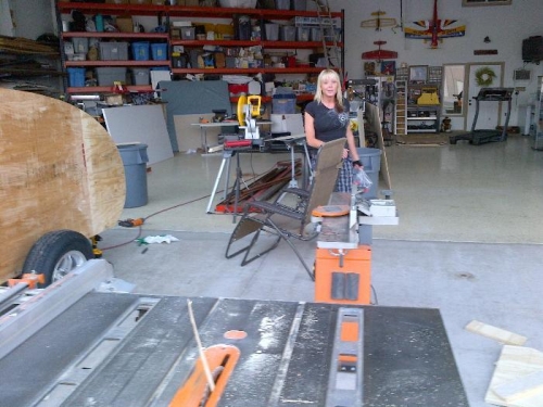 The wife helping run wood through the table saw