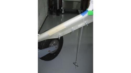 Fitting nose leg fairing; note the improvised plumb bobs for alignment