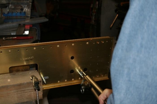 Squeezing the nutplate rivets with the longeron yoke.