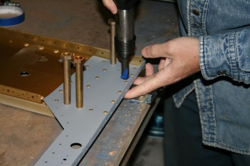Driving the rivets using the bar against the bench. I'm pulling up on the assembly to flush the rivets