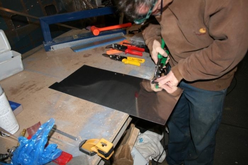 Cutting out the access door with tinsnips.