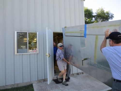 Carrying left wing to back of shop