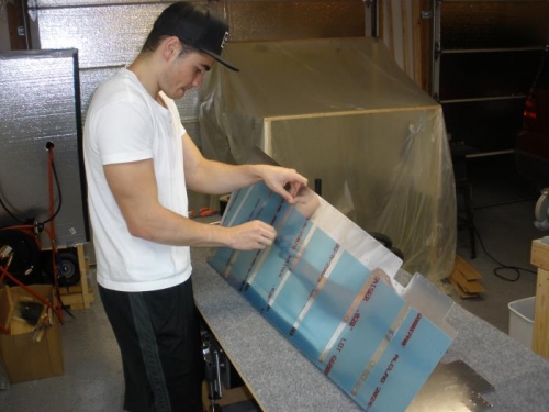 Cutting away vinyl strips aound the rivet holes.