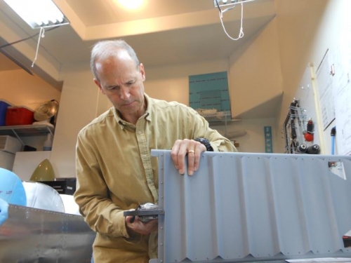 Riveting front seatback hinge in place.