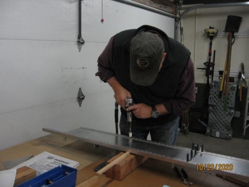 Using the rivet gun to set rivets.