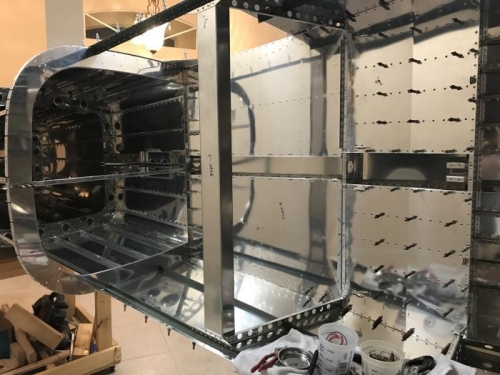 deburred, dimpled, countersunk, and riveting baggage and rear seat skins in