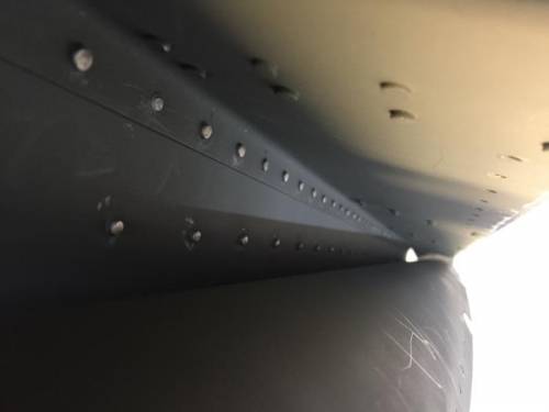 Shop heads after backriveting the aileron gap seal to the upper skins