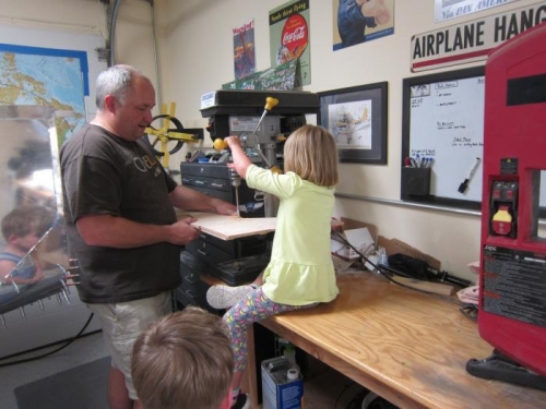 Amelia drills some holes, while Colin looks on.