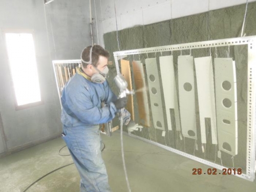 Ben Forget spray painting primer on Seat rib parts