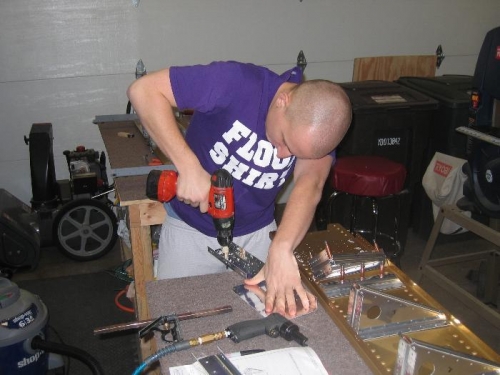 Brad enlaring the holes for the snap bushings with a unibit