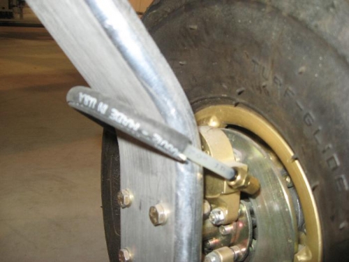 Brake line around gear leg and protected from rubbing